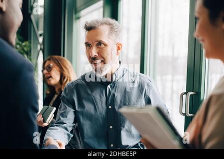 Mature businessman greeting young colleague in meeting at office Stock Photo