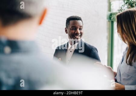 Smiling businessman discussing with coworkers at conference Stock Photo