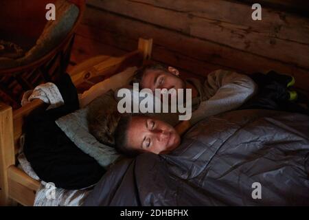 High angle view of couple with blanket sleeping on bed in cottage Stock Photo