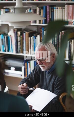 Senior therapist showing analysis to woman at home office Stock Photo