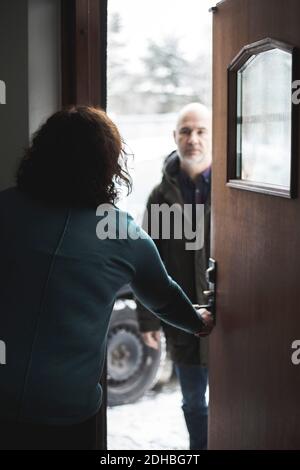 Female doctor opening door for mature patient at home office Stock Photo