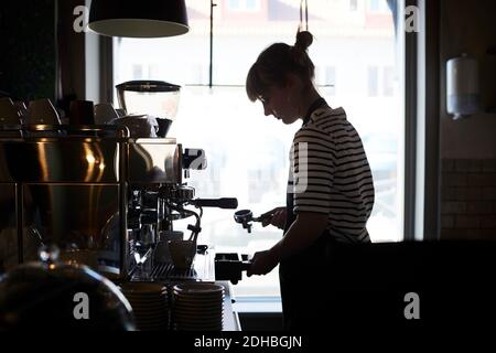 Female barista using coffee filter at cafe Stock Photo