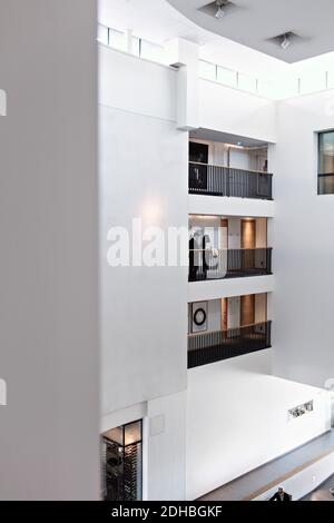 Colleagues discussing while standing in balcony at office Stock Photo