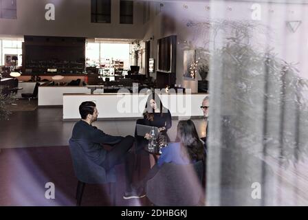 Business people discussing while sitting on chair in lobby at office Stock Photo