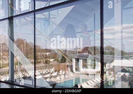 Businesswomen talking while climbing steps seen through glass window in office Stock Photo