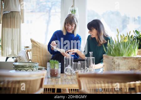 Smiling female owners discussing over documents at boutique Stock Photo