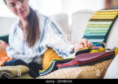 Working mother with daughter choosing fabric from swatch at home office Stock Photo