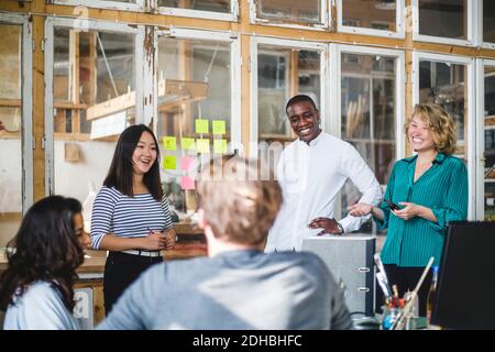Smiling entrepreneurs working on new IT projects in start-up office Stock Photo