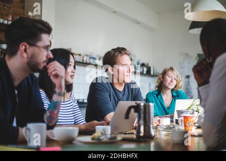 Young IT experts looking away at creative workplace Stock Photo
