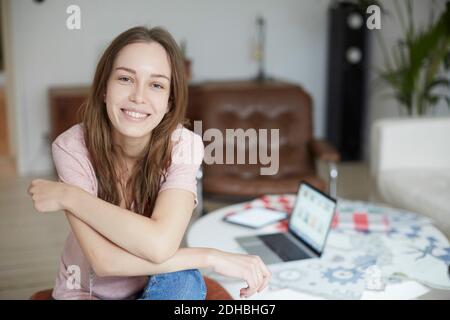 Portrait of smiling fashion designer sitting by table at home Stock Photo