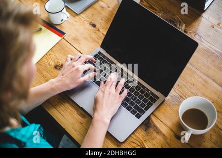 High angle view of female IT expert coding in laptop at desk Stock Photo