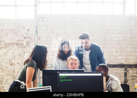 Serious IT experts using desktop PC while coding computer programs in office Stock Photo