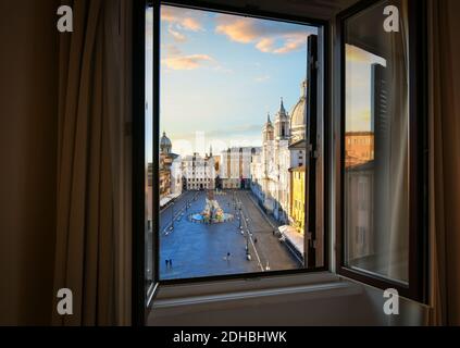View from an open window overlooking the Piazza Navona at sunrise showing Bernini's Fountain of Four Rivers. Stock Photo