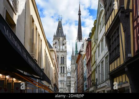 The main street Rue du Gros Horloge with the Rouen Cathedral tower and spires in view and half timbered homes along the way Stock Photo