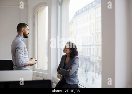 Male and female business colleagues discussing at office Stock Photo