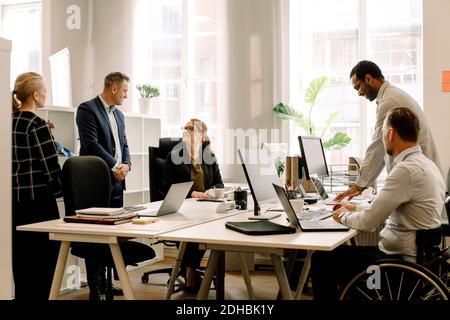 Business professionals working together at desk in office Stock Photo