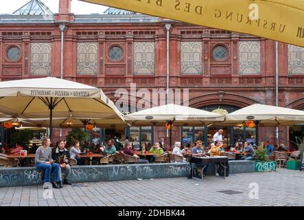 Tourists and locals enjoy lunch at a cafe outdoor in the Hackescher Markt square of Berlin Germany. Stock Photo