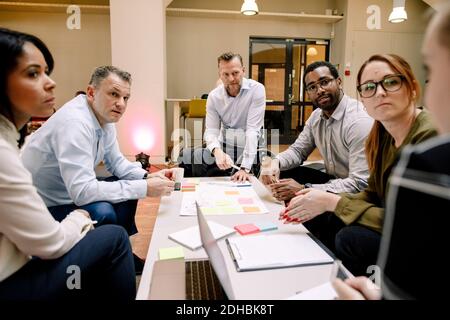 Sales executives looking at businesswoman during meeting in office Stock Photo