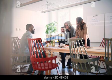 Male engineer showing architectural model to colleagues at table during meeting in office Stock Photo