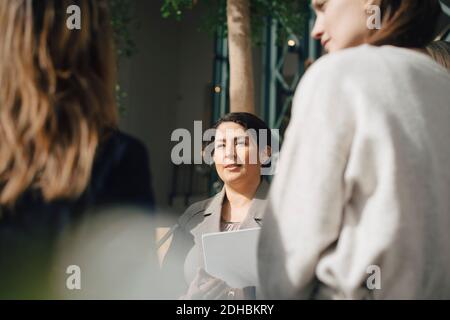 Confident businesswoman with colleagues in conference meeting Stock Photo