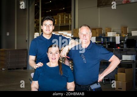 Portrait of confident multi-ethnic workers standing at distribution warehouse Stock Photo