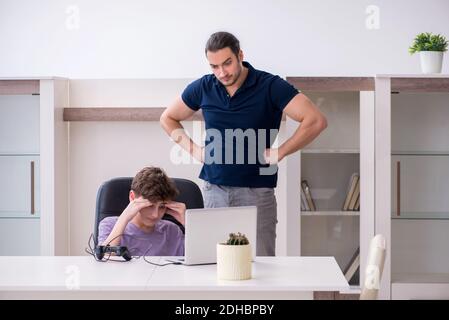 Young father and schoolboy playing computer games at home Stock Photo