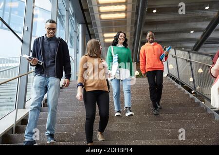 Male and female students walking down steps in university Stock Photo