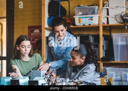 Teacher Assisting Teenage Students In Computer Lab Stock Photo - Alamy