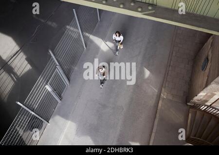 High angle view of male and female friends riding electric push scooters on street in city Stock Photo