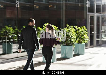 Business colleagues talking while walking in lobby at office Stock Photo