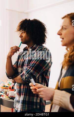 Multi-ethnic technicians looking away while standing at creative office Stock Photo