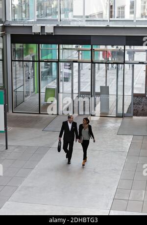 High angle view of male and female business professionals walking in atrium at office Stock Photo