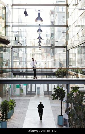 Young businessman standing in lobby at office atrium Stock Photo