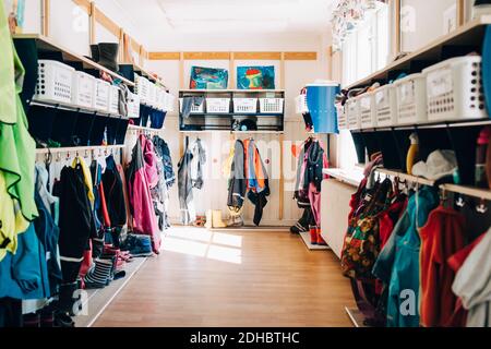 Various clothes hanging in cloakroom at preschool Stock Photo