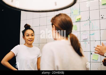 Smiling young businesswoman planning with hackers at creative office Stock Photo