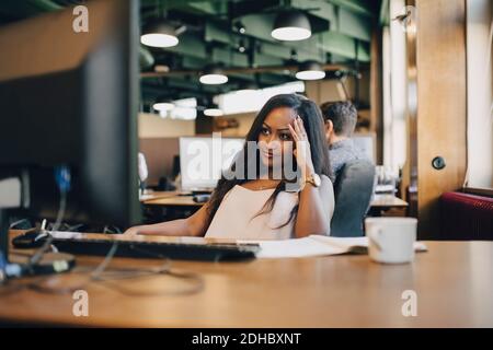 Concentrated businesswoman looking at computer monitor in office Stock Photo