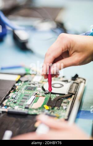 Cropped hand of technician repairing computer part on table Stock Photo