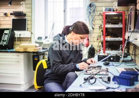 Serious mature woman working in computer workshop Stock Photo