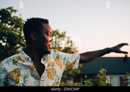 Thoughtful man standing in yard during sunset Stock Photo