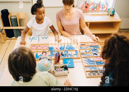 High angle view of teacher teaching spellings to children Stock Photo