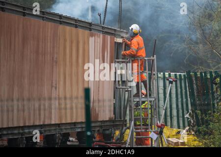 Denham, UK. 8th December, 2020. A HS2 contractor uses a large hammer in the construction of a Bailey bridge to be used to traverse the river Colne as part of pylon relocation works for the controversial HS2 high-speed rail link. Credit: Mark Kerrison/Alamy Live News Stock Photo