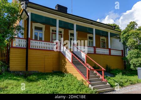 Yellow wooden house in Russian trading block in Suomenlinna fortress, with columned veranda, high entrance steps and stone base, as well as ornamental Stock Photo