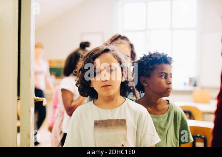 Students lining up at doorway in classroom Stock Photo