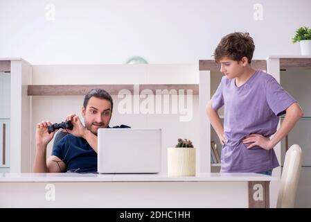 Young father and schoolboy playing computer games at home Stock Photo