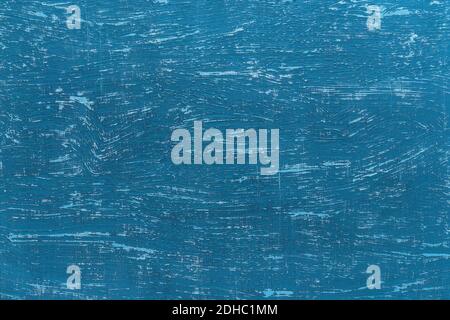 Texture of scratched blue paint on an old rough painted surface. Blue aged wall with turquoise scratches. Abstract construction background design. Stock Photo