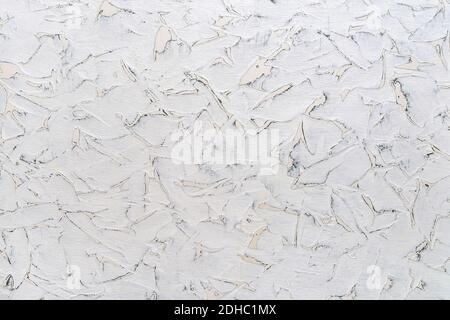 Texture of cracked white paint on a surface with spots of different shapes. White aged wall with gray scratches. Abstract construction background. Stock Photo