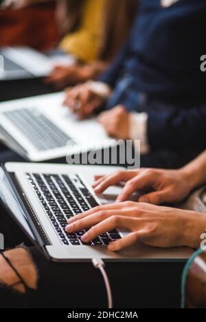 Midsection of colleagues using laptops in creative office Stock Photo