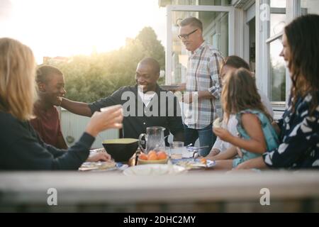 Cheerful multi-generation family enjoying lunch at porch Stock Photo