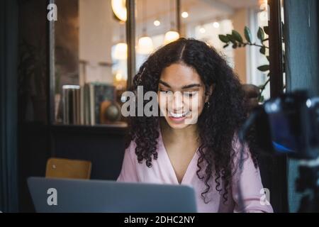 Smiling young businesswoman using laptop at creative office Stock Photo