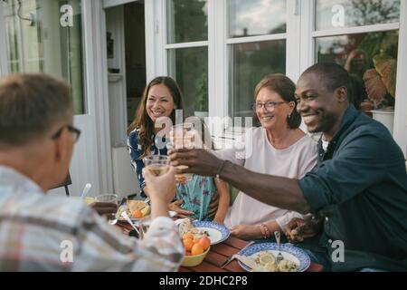 Happy multi-generation family toasting drinks at table during garden party Stock Photo
